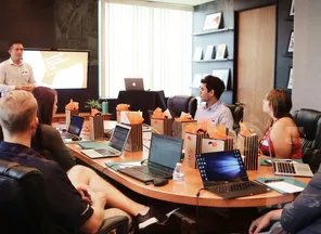 A presenter leading a working session for a team at laptops