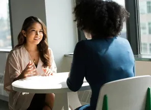 Two professionals in a one-to-one discussion by a window